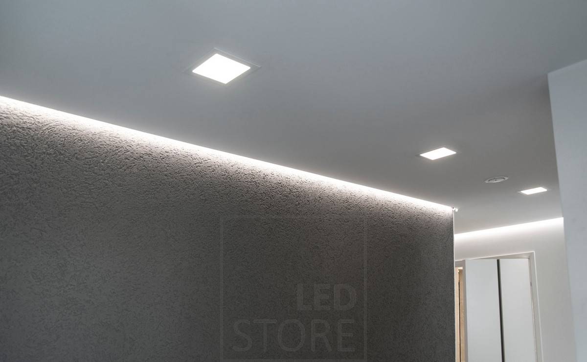 Flurbeleuchtung mit indirektem Licht, installiert in einer Nut zwischen Decke und Wand. Zusätzlich sorgen Paneelleuchten an der Decke für eine flächige Allgemeinbeleuchtung. Ledstore.fi