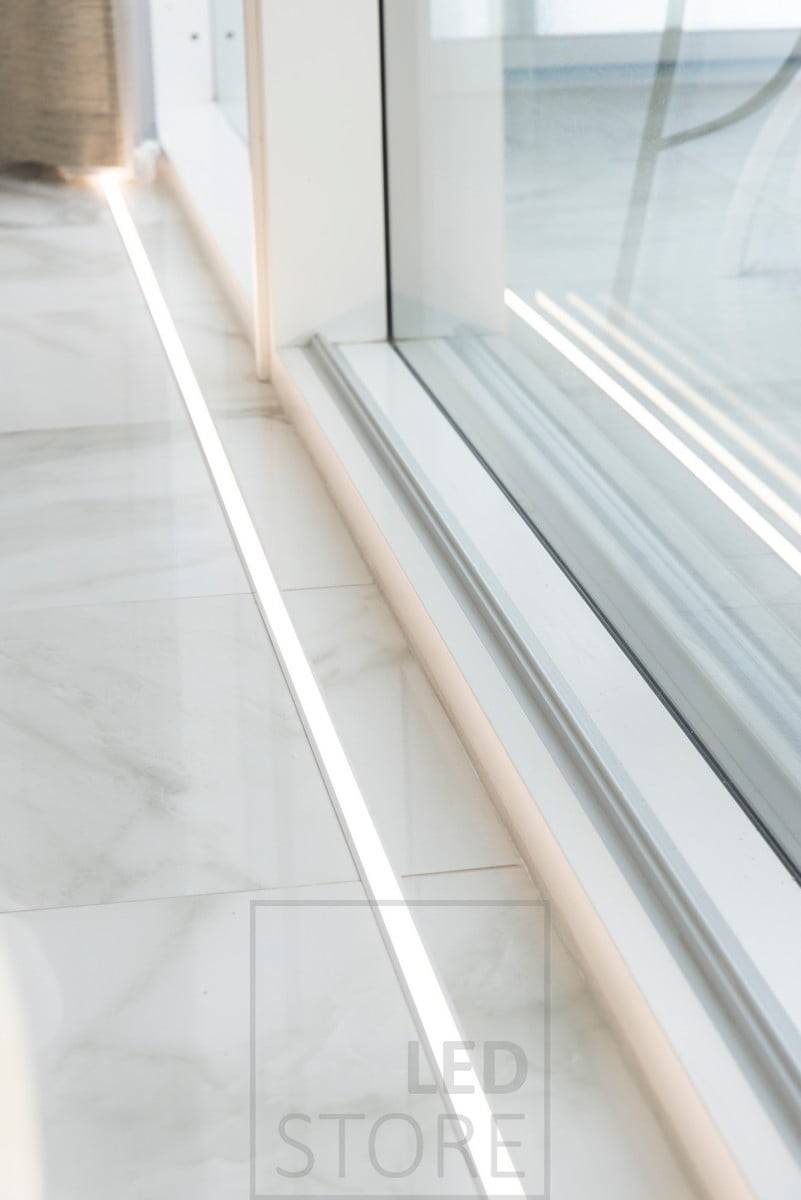 Vor den bodentiefen Fenstern: LED-Leiste in einem Einbauprofil. Das Uplight akzentuiert die Fenster und hebt den schönen Marmorboden hervor. Ledstore.fi