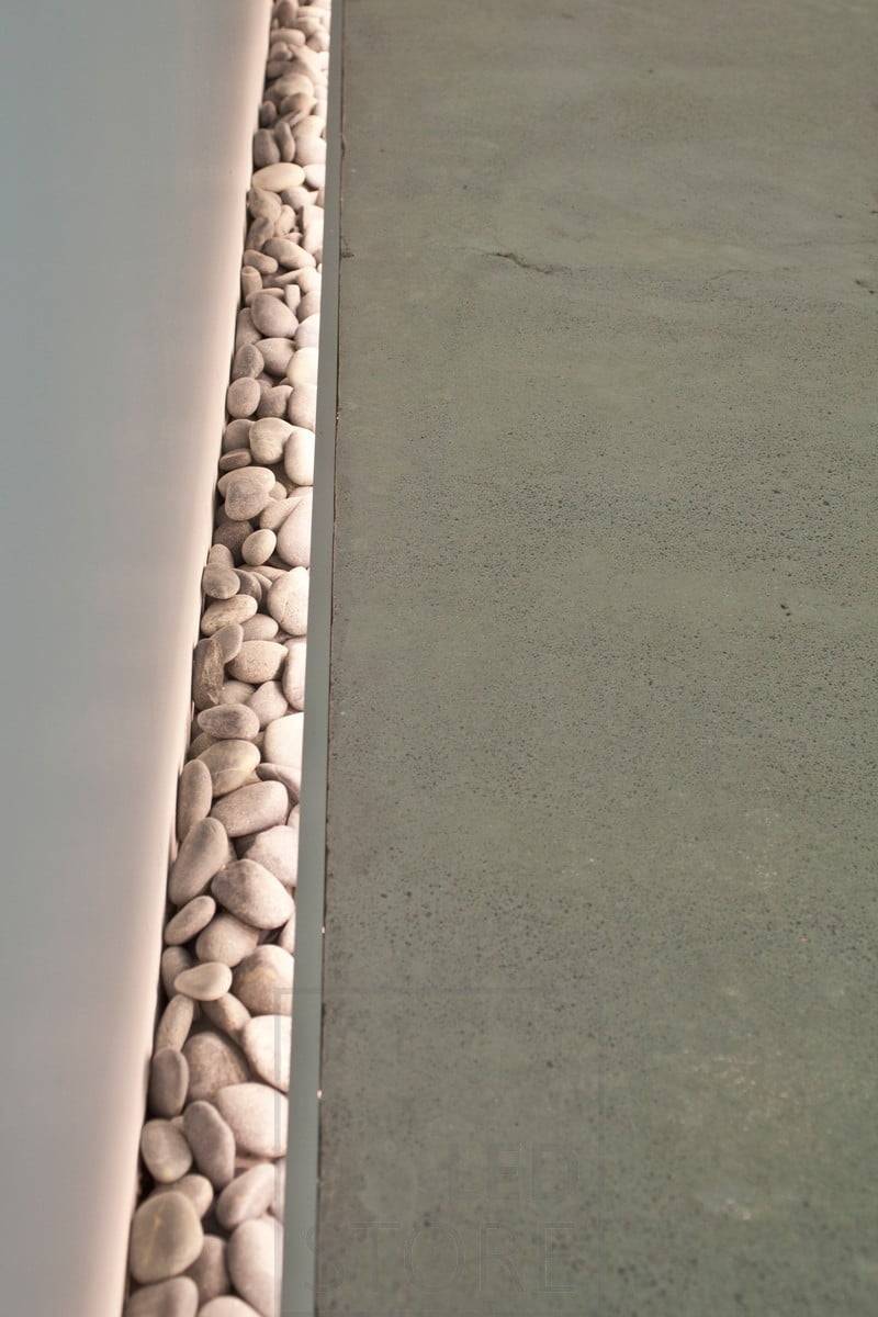 Wunderschöne Details auf dem Boden. Beim Gießen des Fußbodens wurde eine kleine Aussparung an der Wand gelassen, um Steine einzubringen, und es wurde eine stimmungsvolle Beleuchtung installiert, um die Steine hervorzuheben. Funktioniert auch als stimmungsvolles Nachtlicht. Ledstore.fi