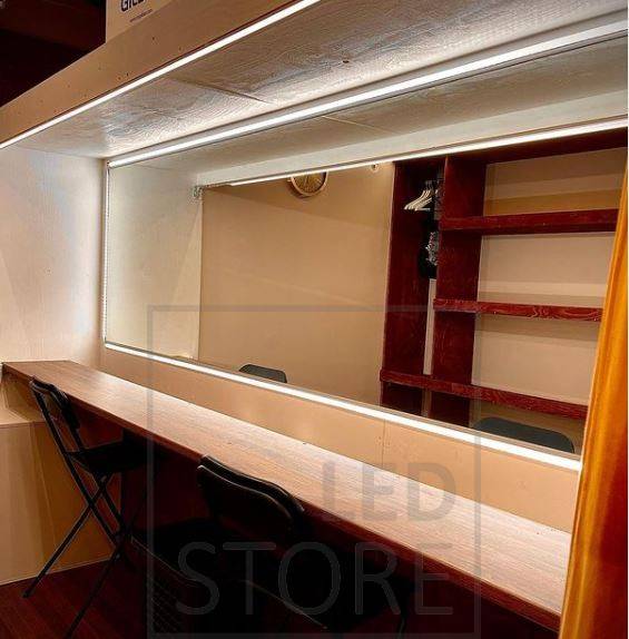 Mit Strahlern und stimmungsvollem indirektem Licht beleuchtete Turnhalle. Die indirekte Beleuchtung wird durch ein LED-Lichtband erreicht, das zwischen der Decke und der Wand installiert ist.