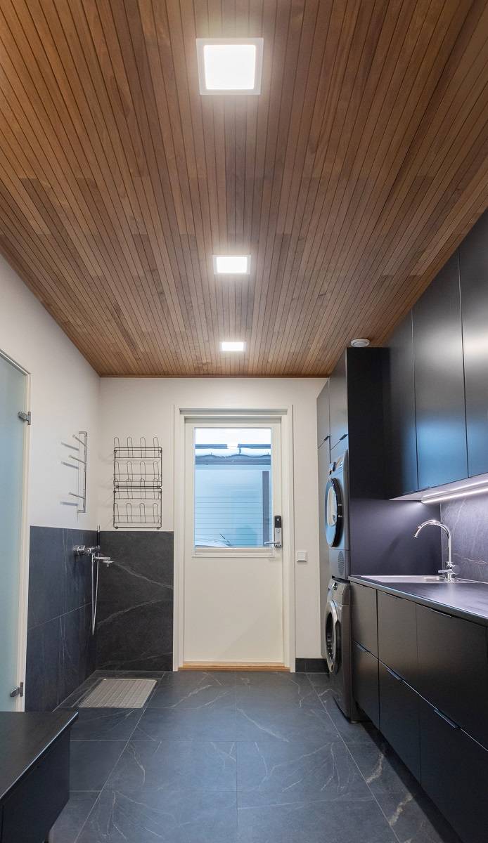 Kleine rechteckige LED-Paneele an der Decke des Hauswirtschaftsraums und eine LED-Leiste auf der Arbeitsplatte.