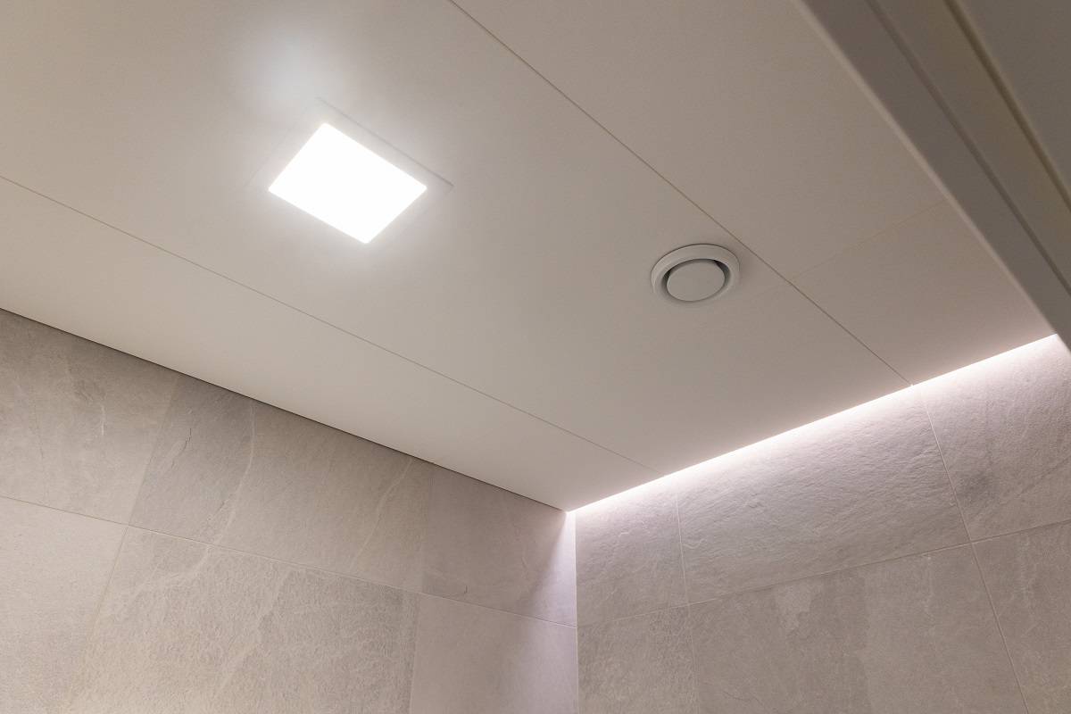 LED-Leiste in der Aussparung zwischen Decke und Wand und ein kleines, quadratisches LED-Paneel in der Decke.