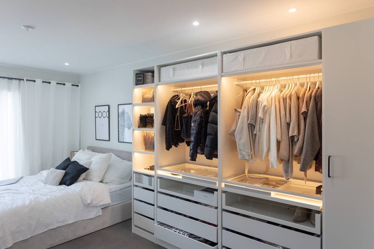 Schlafzimmer mit runden Strahlern und Kleiderschrank mit LED-Beleuchtung.
