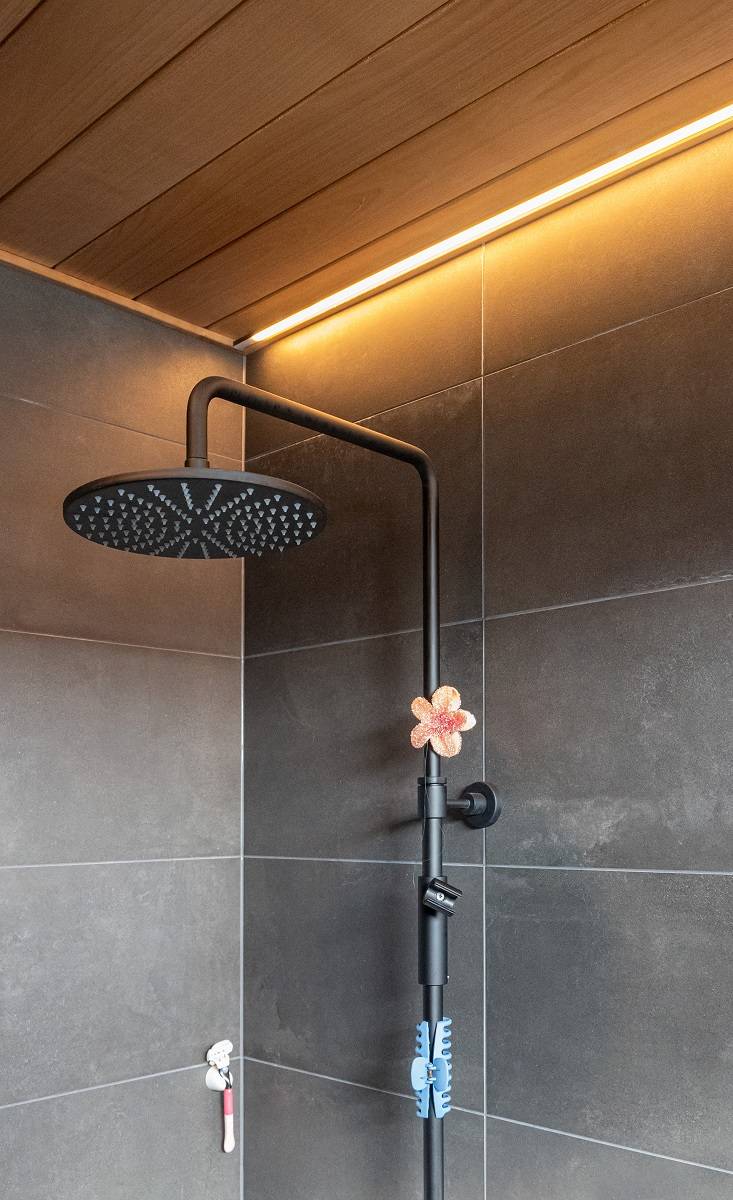 Badezimmer mit in die Decke eingelassenen LED-Leisten neben der Wand.