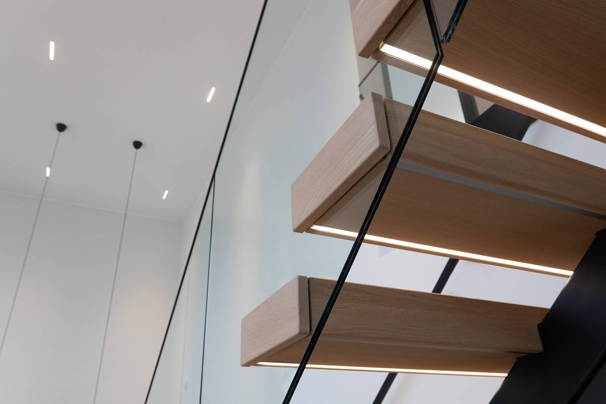 LED-Streifen an der Unterseite der Stufen einer offenen Treppe.