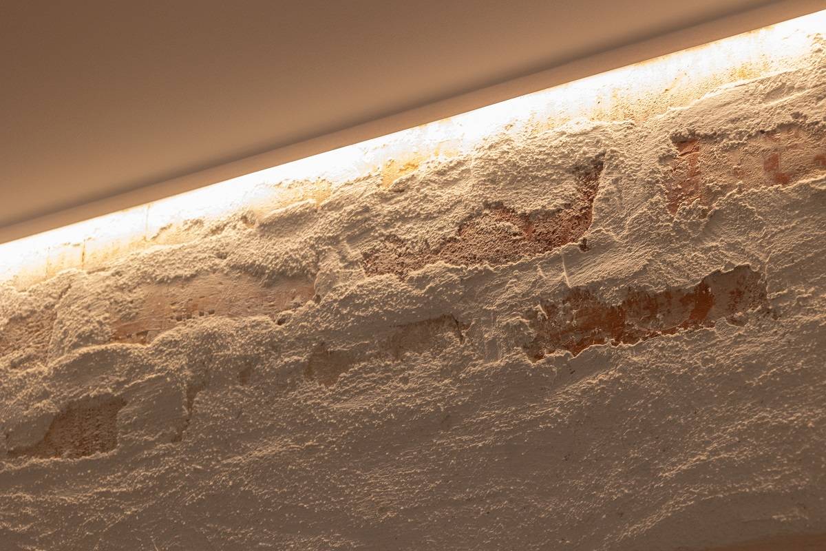 LED-Streifen, der am oberen Rand der Akzentwand angebracht ist und nach unten leuchtet.