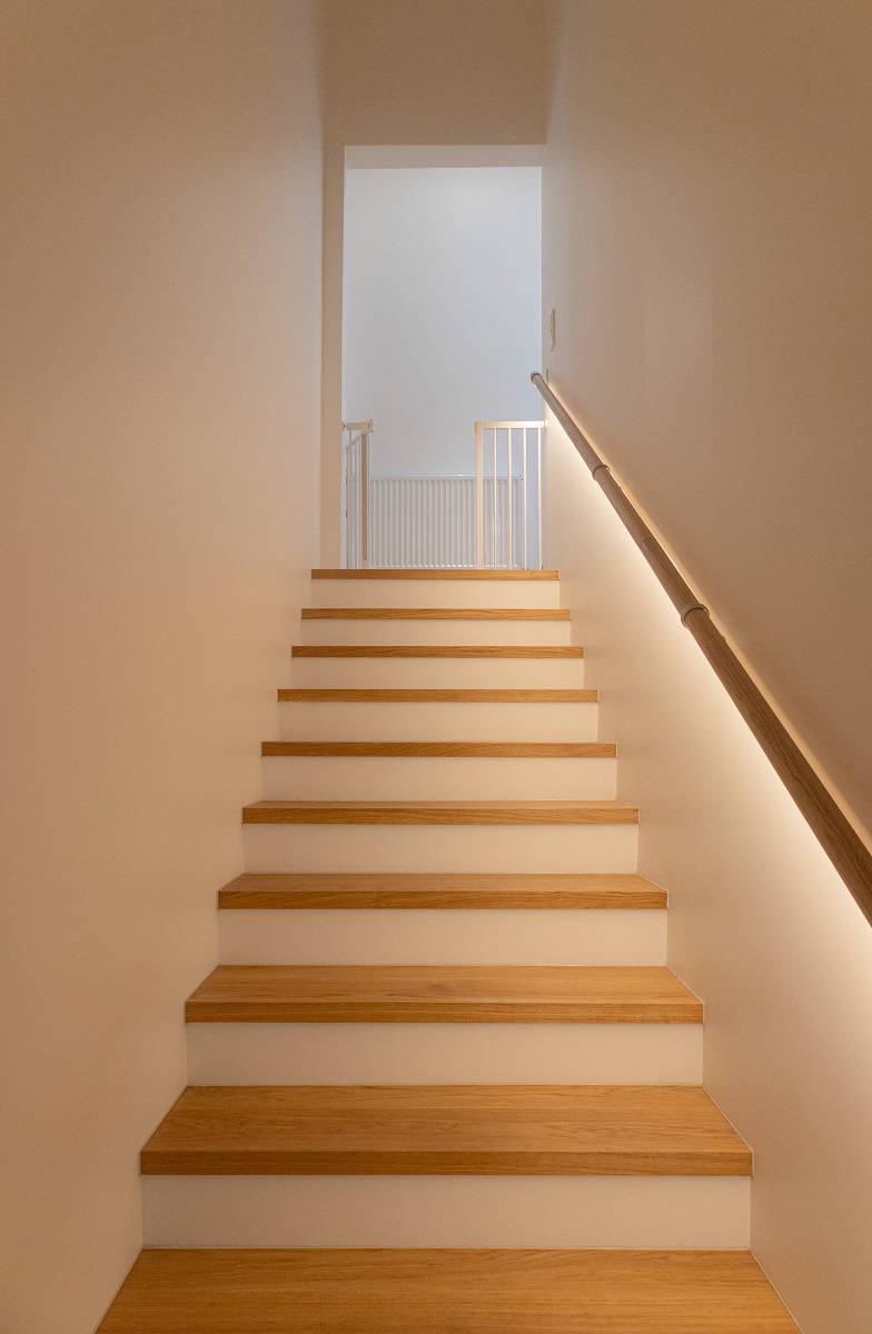 Die Treppe wird durch ein unter dem Geländer angebrachtes LED-Band beleuchtet.