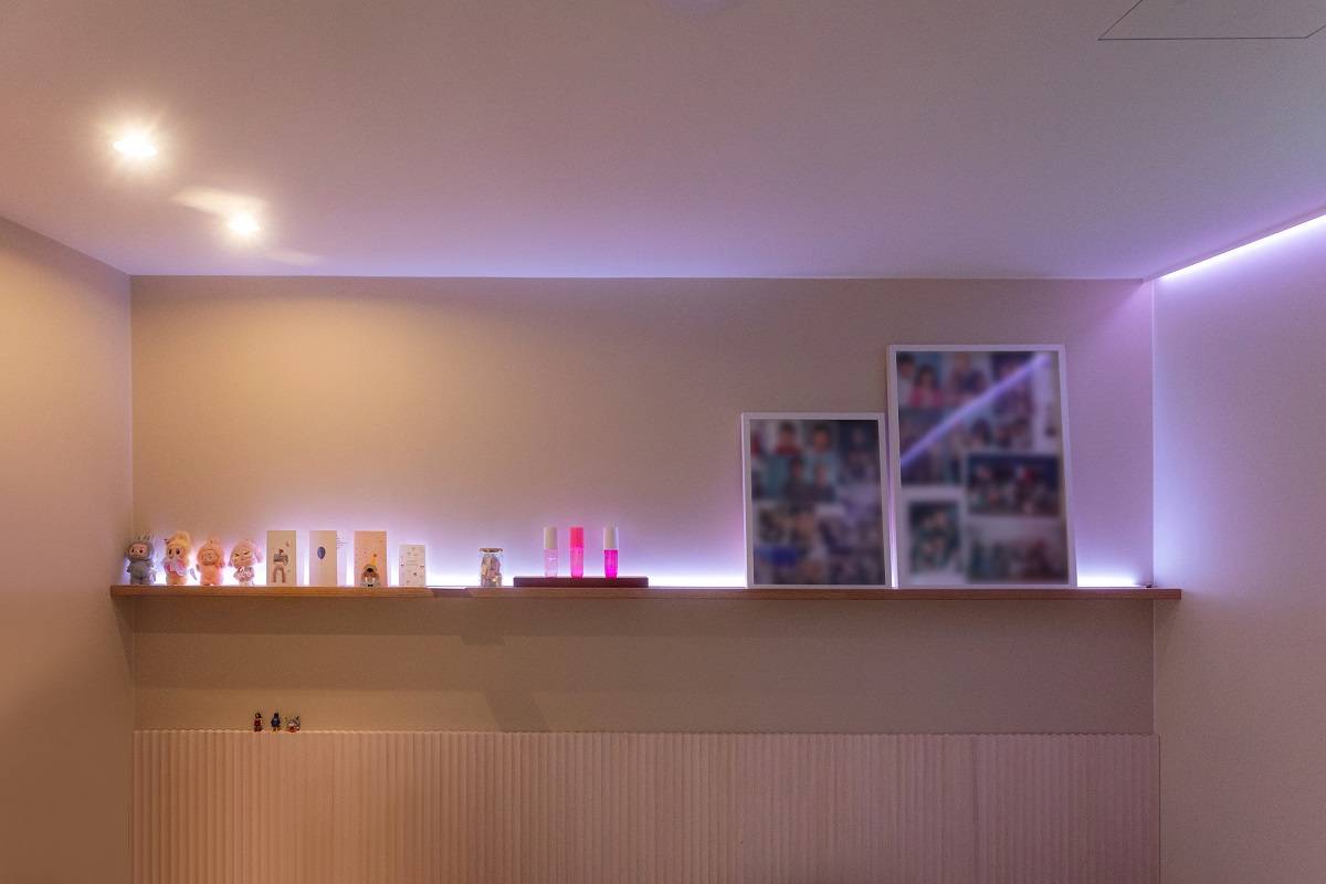 Ein LED-Band, das lila Licht spendet, verläuft um den Raum herum; an der Decke befinden sich außerdem zwei Strahler.