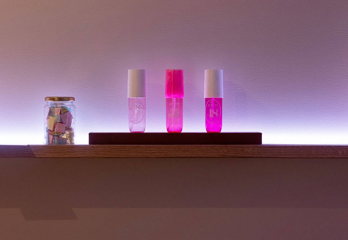 Ein hinter dem Regal angebrachtes LED-Band mit einstellbarer Farbe wirft einen violetten Lichtstreifen an die Wand.