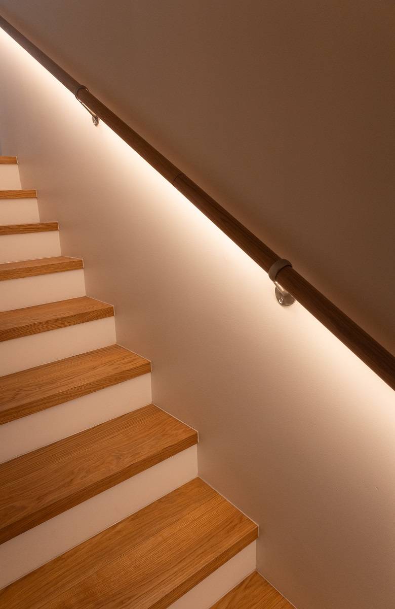 Unter dem Geländer der Treppe schimmert Licht hervor.