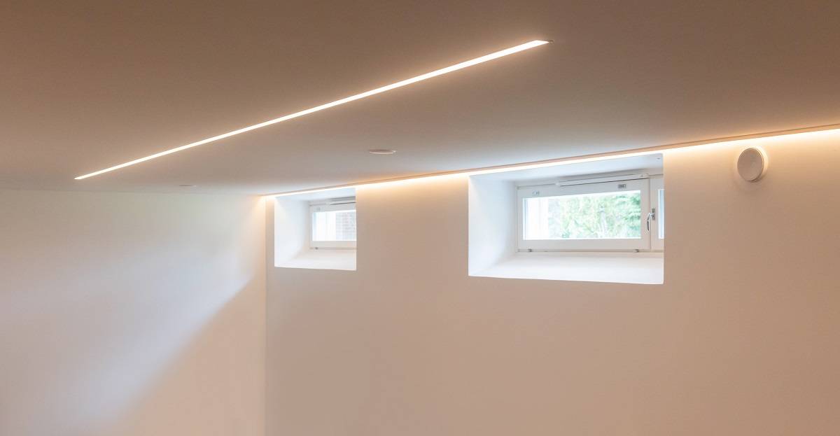 LED-Lichtband an der Wand hinter der Leiste und versenkt in der Mitte der Decke installiert.