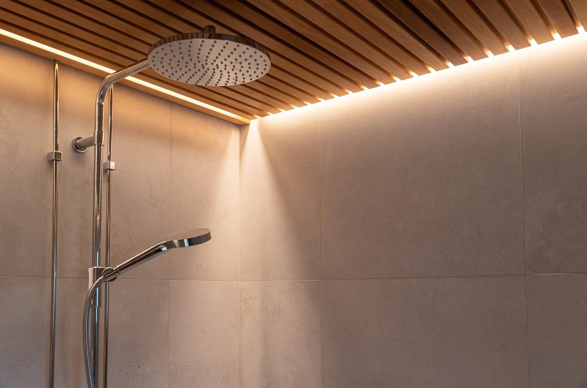 In die Lamellendecke des Duschraums ist ein LED-Streifen eingelassen.