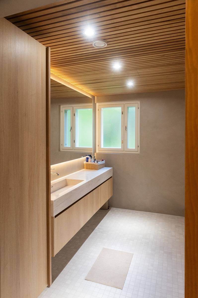 An der Badezimmerdecke befinden sich Strahler und hinter dem Spiegel ein LED-Lichtband.