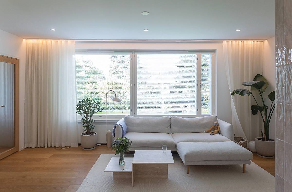 Hinter der Vorhangleiste im Wohnzimmer befindet sich ein LED-Band, und an der Decke sind Strahler angebracht.