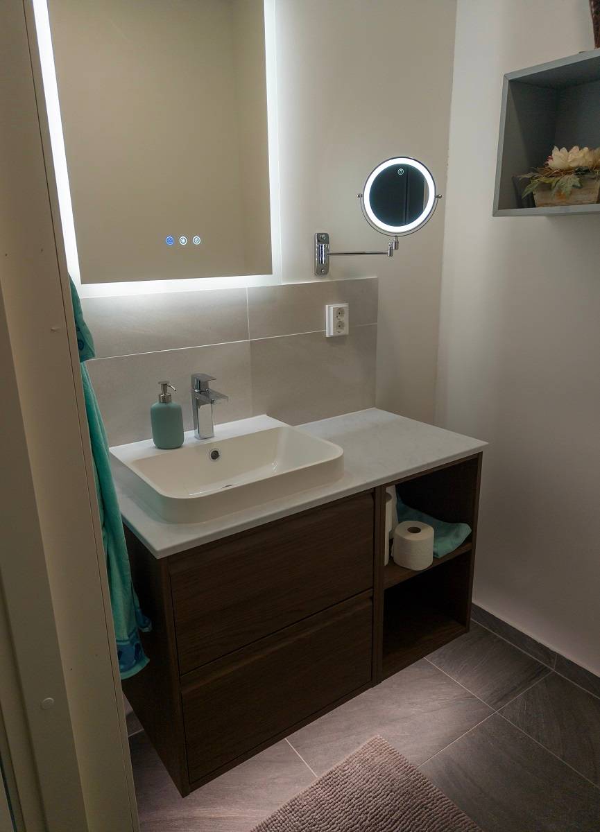 Zusätzlich zu den LED-Leisten im Badezimmer ein Lichtspiegel und eine kleine runde Panellampe