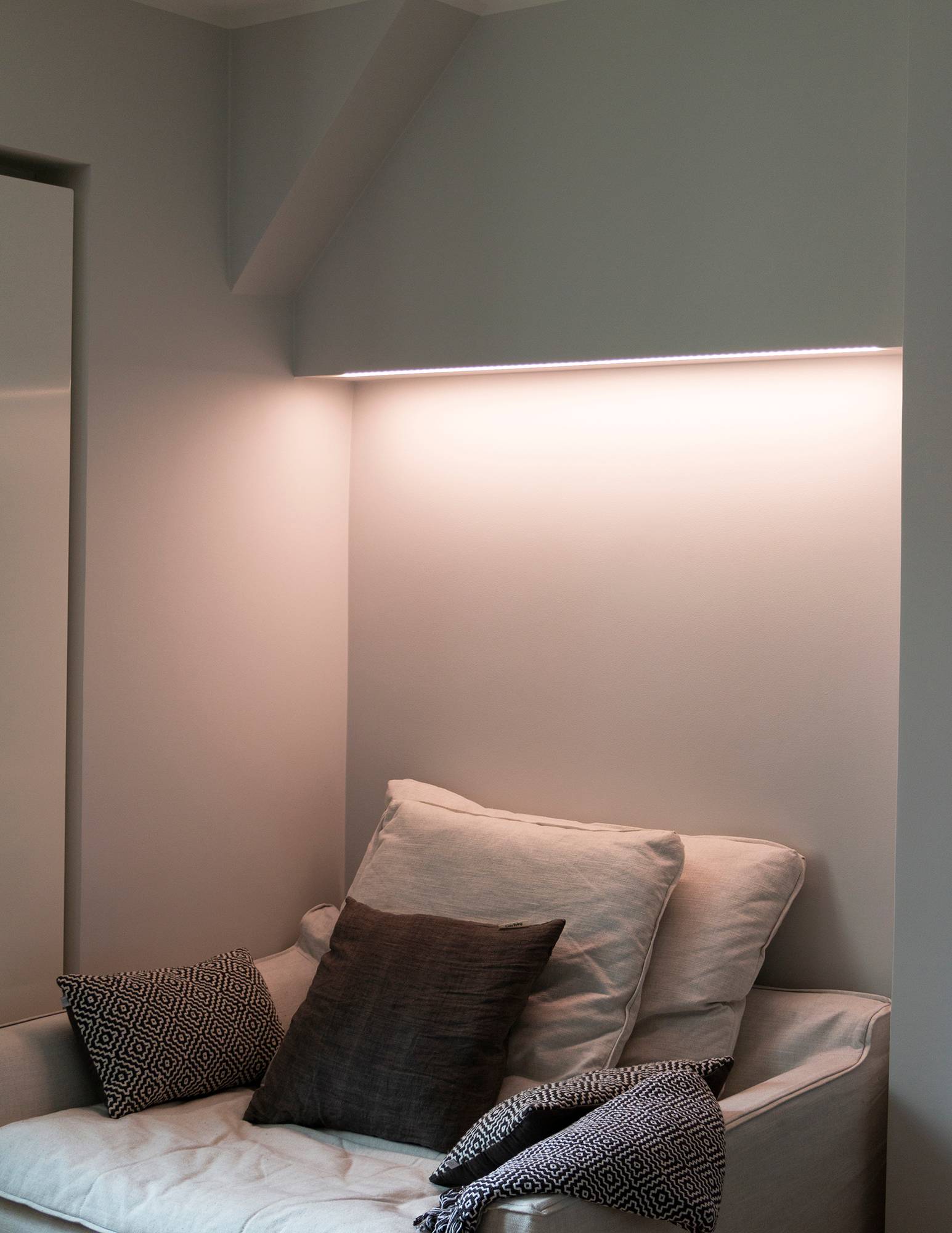 Schlafzimmer mit in der Farbtemperatur einstellbarer Stimmungsbeleuchtung hinter dem Bett, LED-Leiste an der Unterseite des Schranks in einer flachen Oberfläche montiert. Ledstore.fi