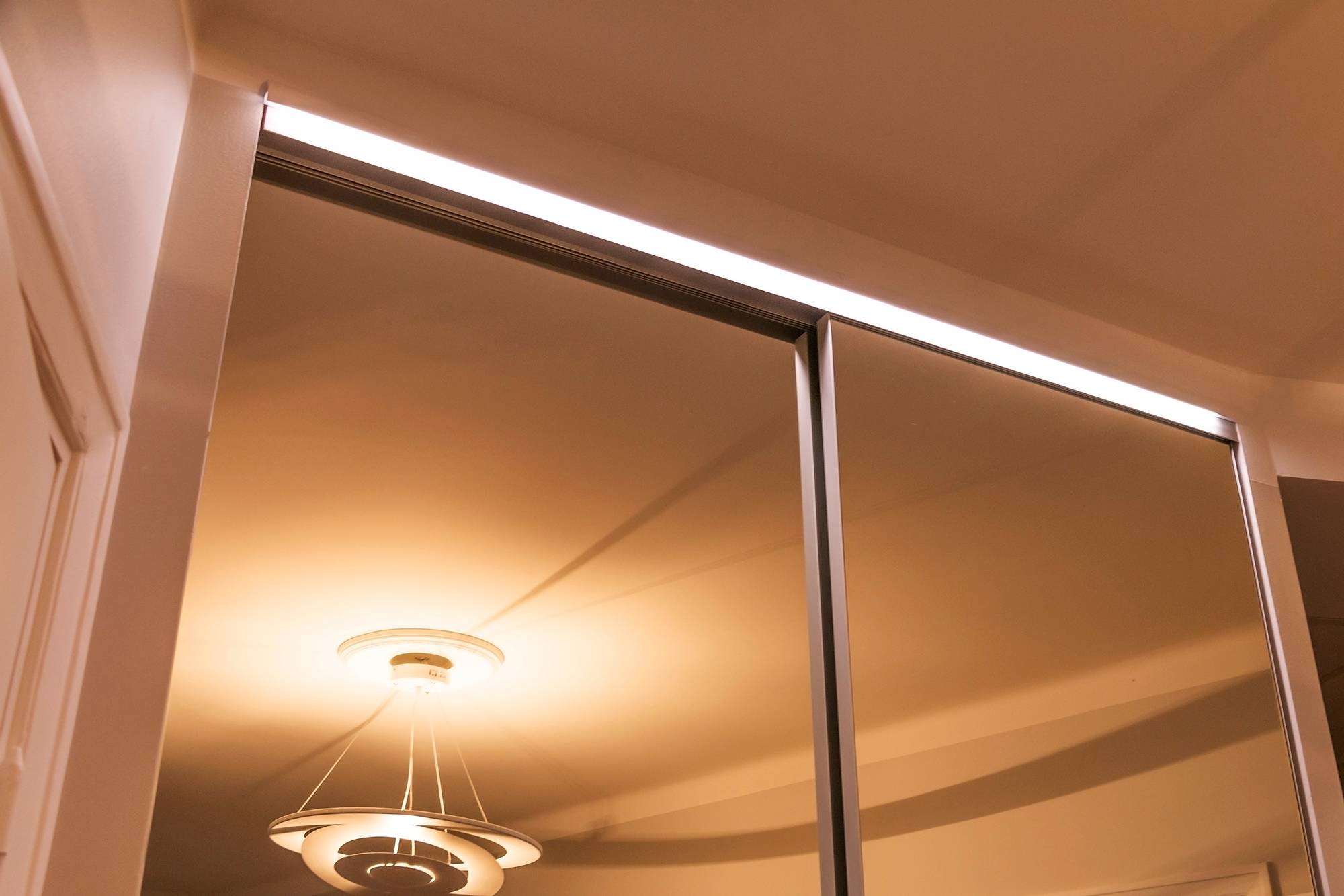 LED-Leiste an der Schublade des Kleiderschranks, die den Spiegel und das Innere des Schranks mit indirektem Licht beleuchtet. Ledstore.fi