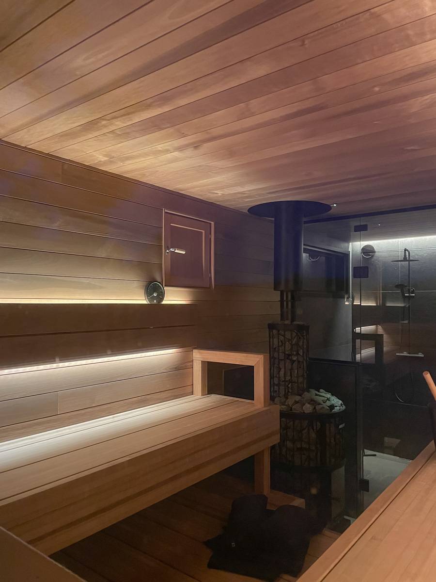 Ein Kamin mit zwei LED-Leisten hinter der Rückenlehne. Das Licht wird an der Decke und der unteren Badewanne reflektiert.