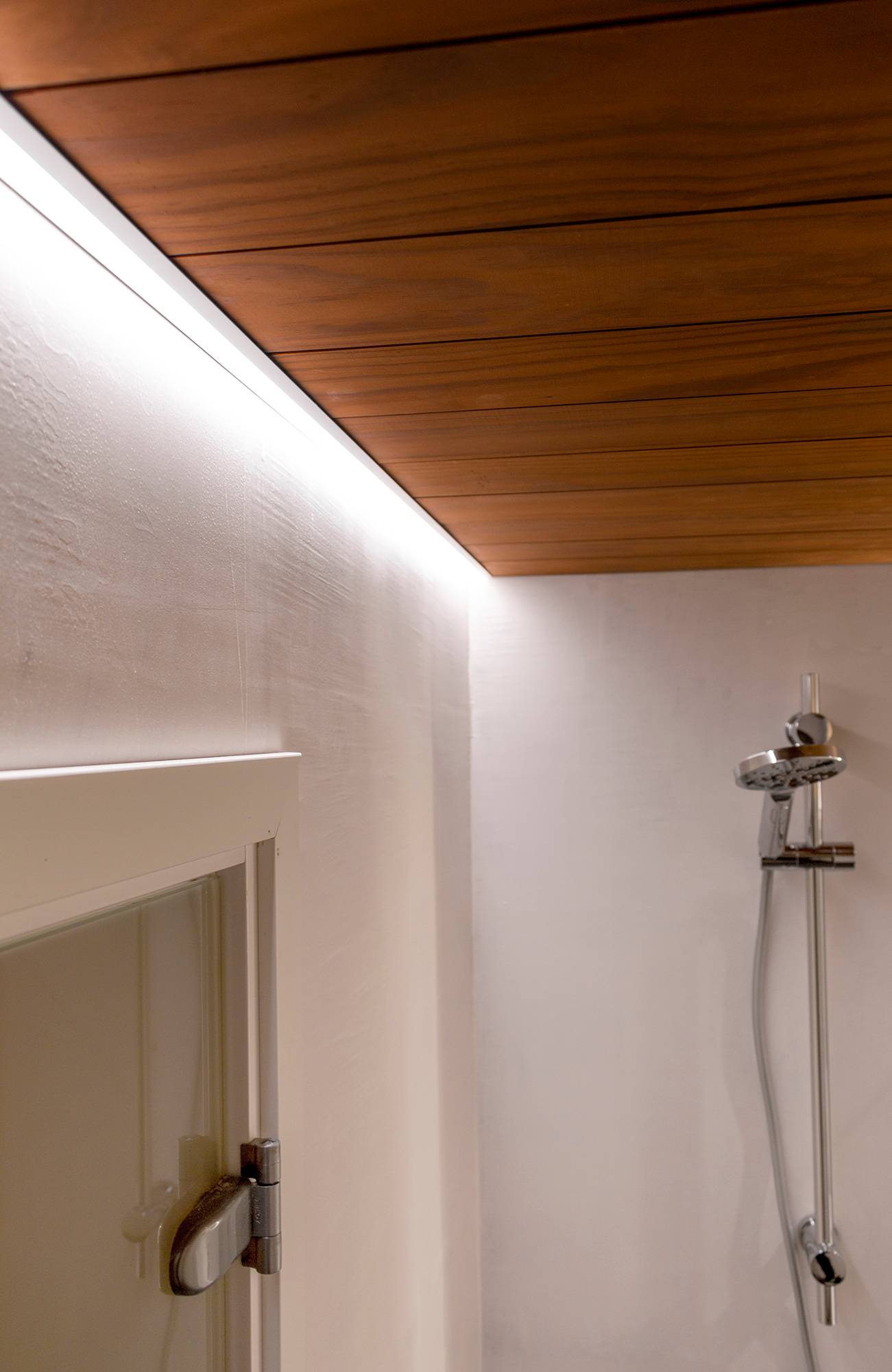 Ein mit der Decke bündig abschließender LED-Streifen am Randprofil beleuchtet die Dusche. Ledstore.fi