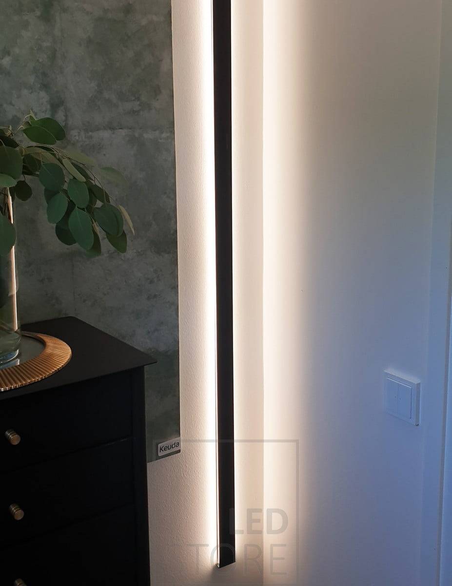 Schwarzes, in zwei Richtungen beleuchtetes Wandprofil, das vertikal montiert wird. Scheint durch die Wand hindurch und sorgt für stimmungsvolles, indirektes Licht im Raum. Ledstore.fi