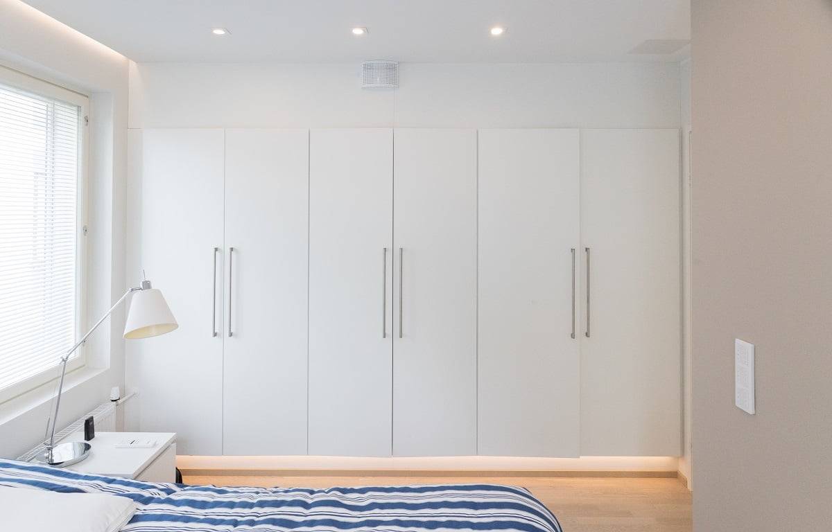 Vor dem Schrank wird die Allgemeinbeleuchtung durch gerichtete 9W Kantti-Strahler gewährleistet. Atmosphärisches Flurlicht mit LED-Profil am Sockel des Schrankes © LedStore