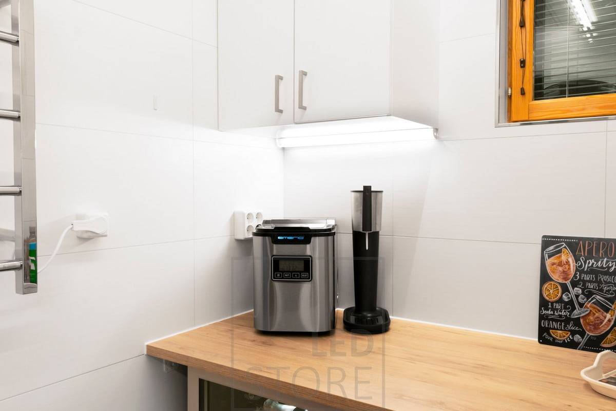 Unter dem Schrank, an der Ecke von Wand und Schrank, ein breites Eckprofil mit LED-Leiste, die die Arbeitsplatte beleuchtet. Das Profil kann bis zu drei LED-Leisten aufnehmen. Ledstore.fi