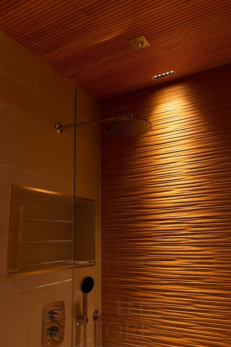 Die schönen strukturierten Fliesen in der Dusche werden durch die LINJA 5-Beleuchtung akzentuiert. Ledstore.fi