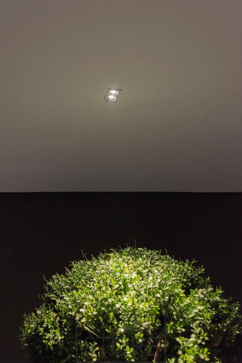 Ein kleiner LINJA 2-Strahler auf dem Dach der Terrasse, der stimmungsvolles Licht erzeugt und die Pflanzen im Freien beleuchtet. Ledstore.fi