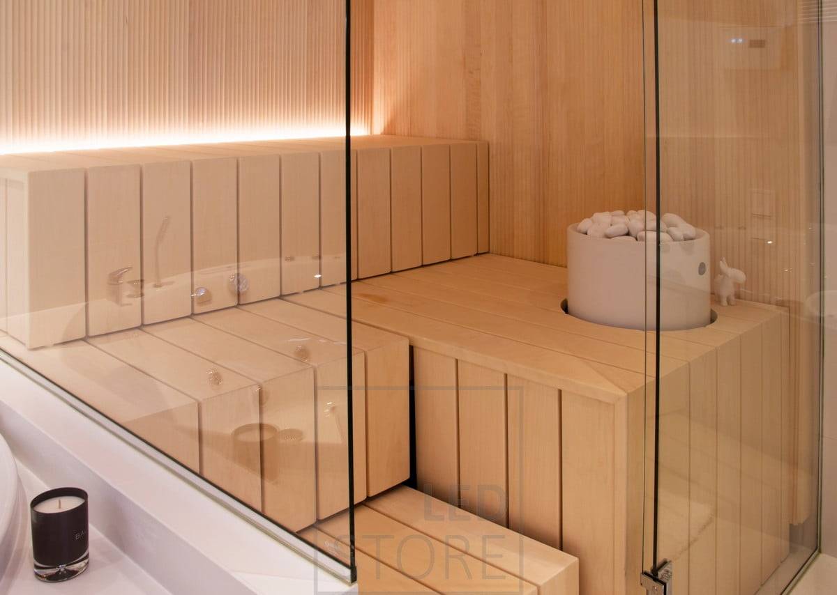 Saunabeleuchtung mit LED-Streifen in der Rille hinter der Bank, Licht nach oben gerichtet. Ledstore.fi