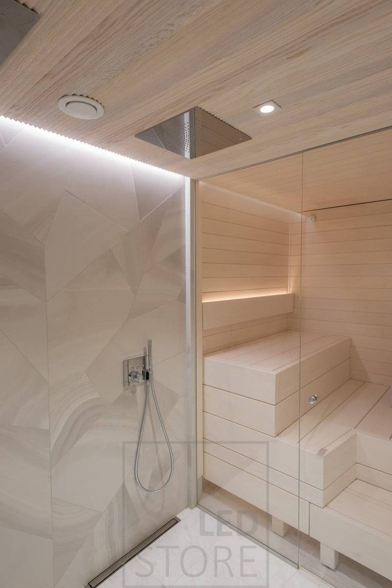 Indirektes Licht im Waschraum und in der Sauna. Im Waschraum in der Decke, in einer Rille zwischen Decke und Wand; in der Sauna in der Rückenlehne, nach oben gerichtet. Außerdem Spotbeleuchtung an der Decke vor den Duschen. Ledstore.fi