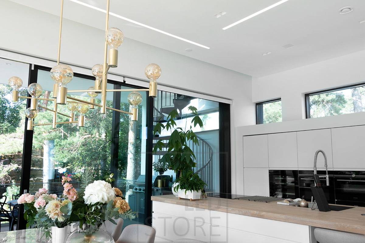 Breite, flächenbündige Profile im Wohnzimmer und in der offenen Küche schaffen schöne, gut beleuchtete Lichtlinien. Ledstore.fi