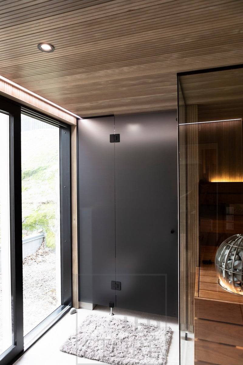 An der Decke geführter Strahler 023 in Schwarz und über den Fenstern geführter Streifen in einem schmalen bündigen Profil. Ledstore.fi