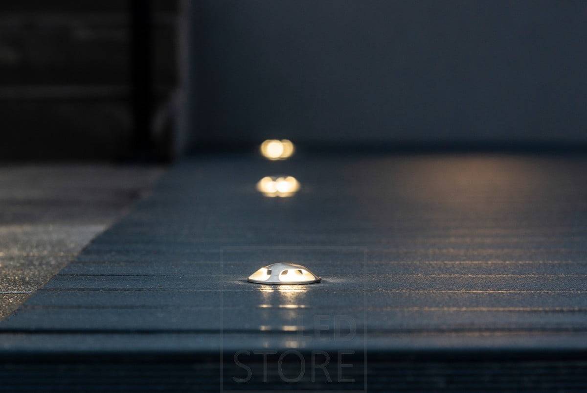 Terrassentopf mit vierfacher Beleuchtung. Das Gestell ist aus rostfreiem Stahl und kann auch in den Boden und die Pflasterung eingelassen werden. Es ist seewasser- und kippsicher. Ledstore.fi
