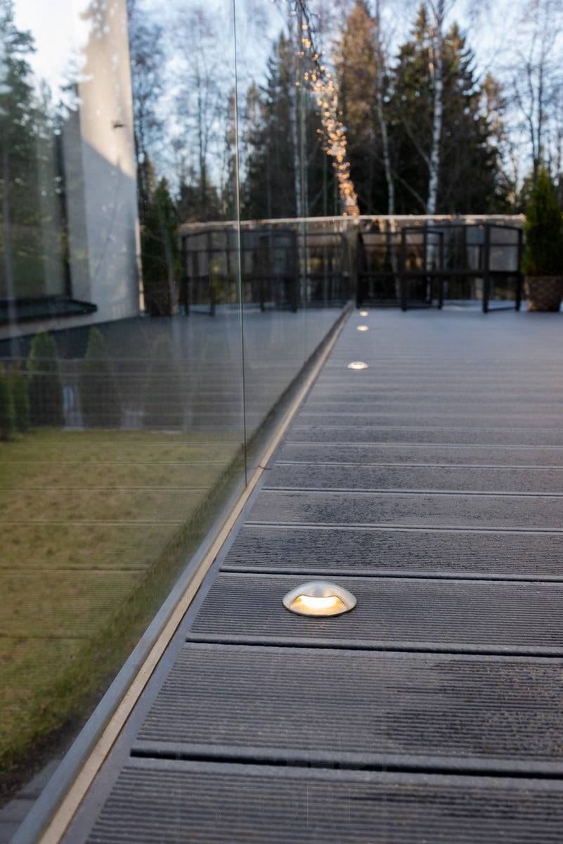 Bidirektional beleuchtete Terrassenstrahler neben den Fenstern. Die Lampen sorgen für weiches, indirektes Licht auf der Terrasse. Ledstore.fi