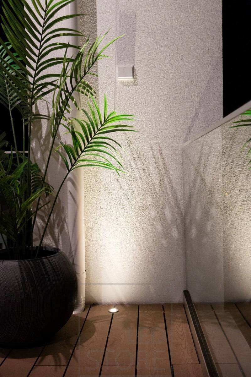 Ein nach oben strahlender Strahler, der in die Terrasse eingelassen ist, nutzt die Wand als reflektierende Fläche, um ein stimmungsvolles Licht von unten nach oben zu werfen. Ledstore.fi