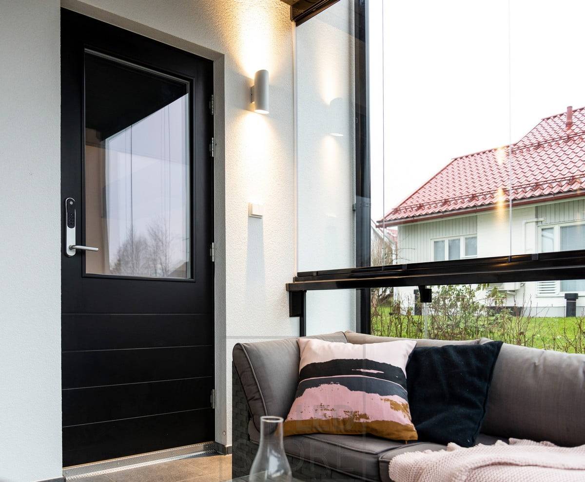 Weiße Viisto Wandleuchte neben dem Eingang. Die Leuchte beleuchtet die Wand in zwei Richtungen mit einem warmen und weichen 3000K-Licht. Ledstore.fi