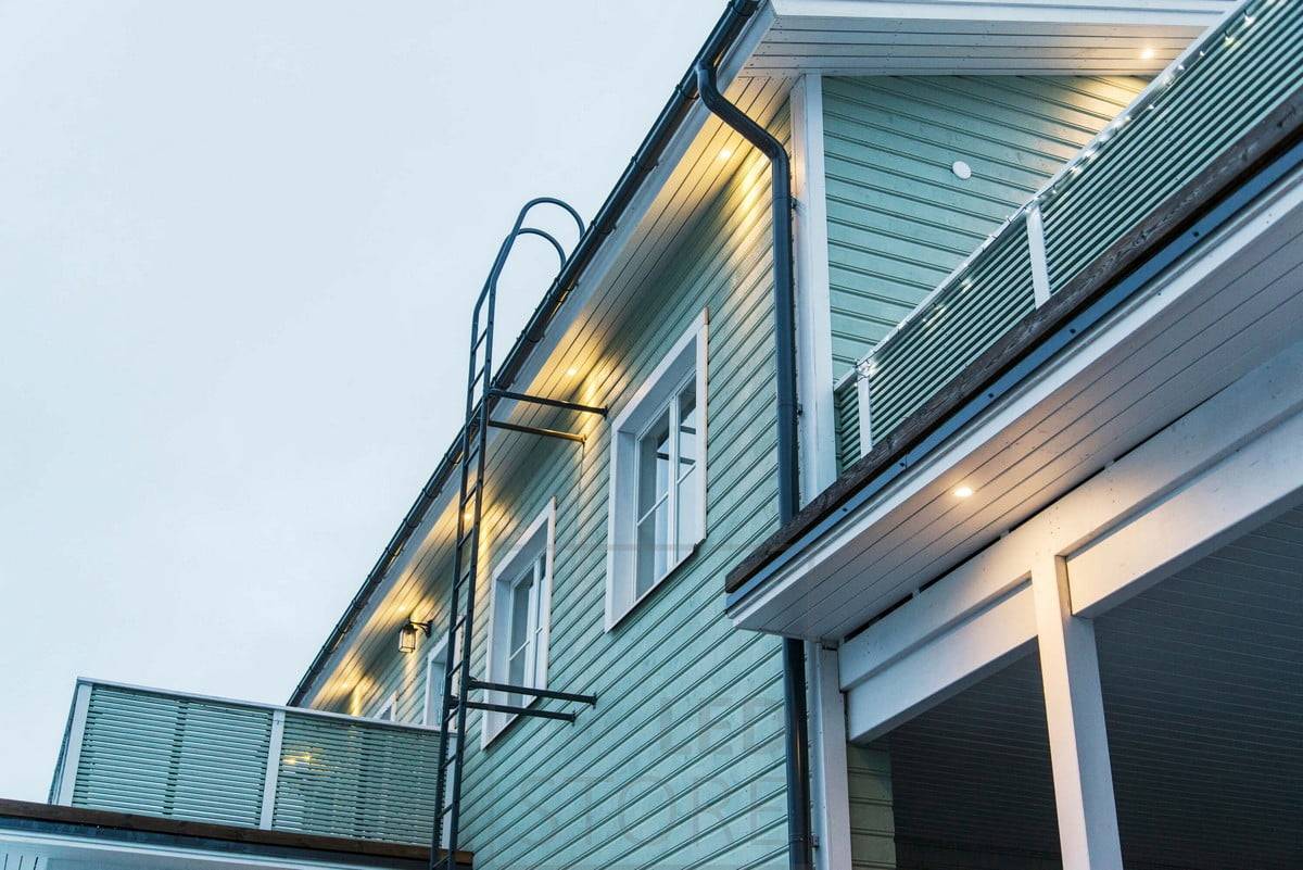 Außenbeleuchtung der Fassade durch an einer Dachrinne montierte Strahler. Ledstore.fi