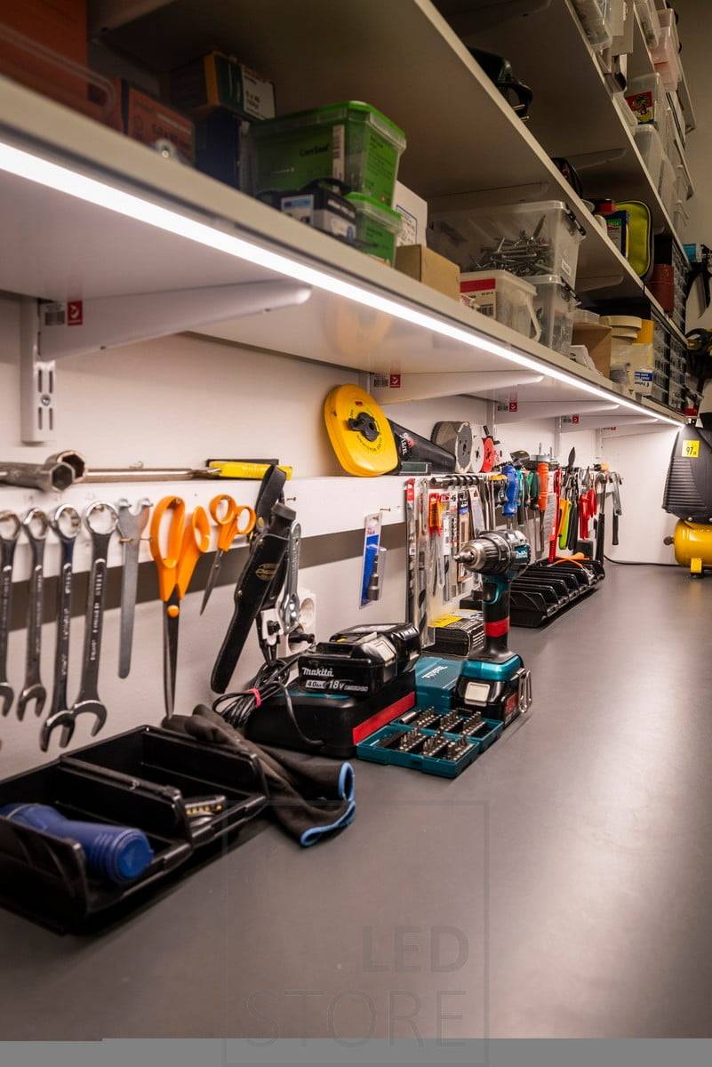 Led-Leiste an der Unterseite eines Regals zur Beleuchtung eines Arbeitsplatzes in einem Lager. Ledstore.fi