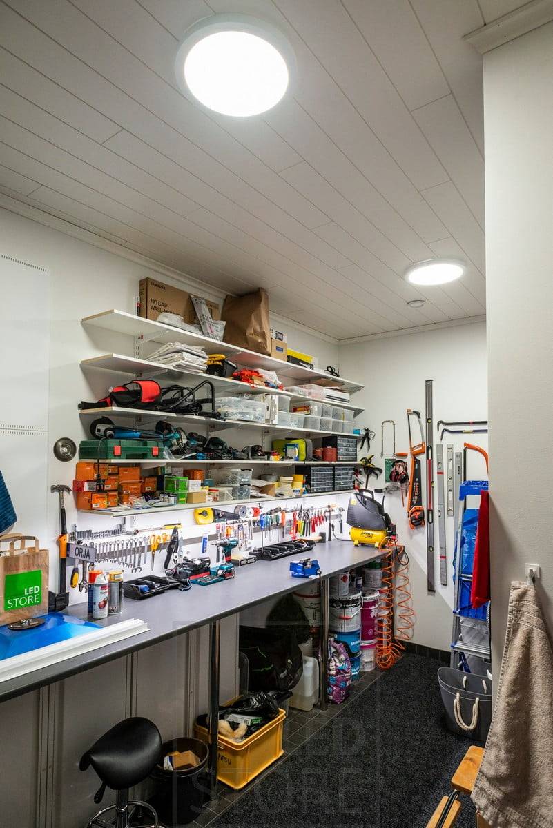 Ein Arbeitsplatz in einem Lagerhaus mit großen Deckenleuchten an der Decke. Ledstore.fi