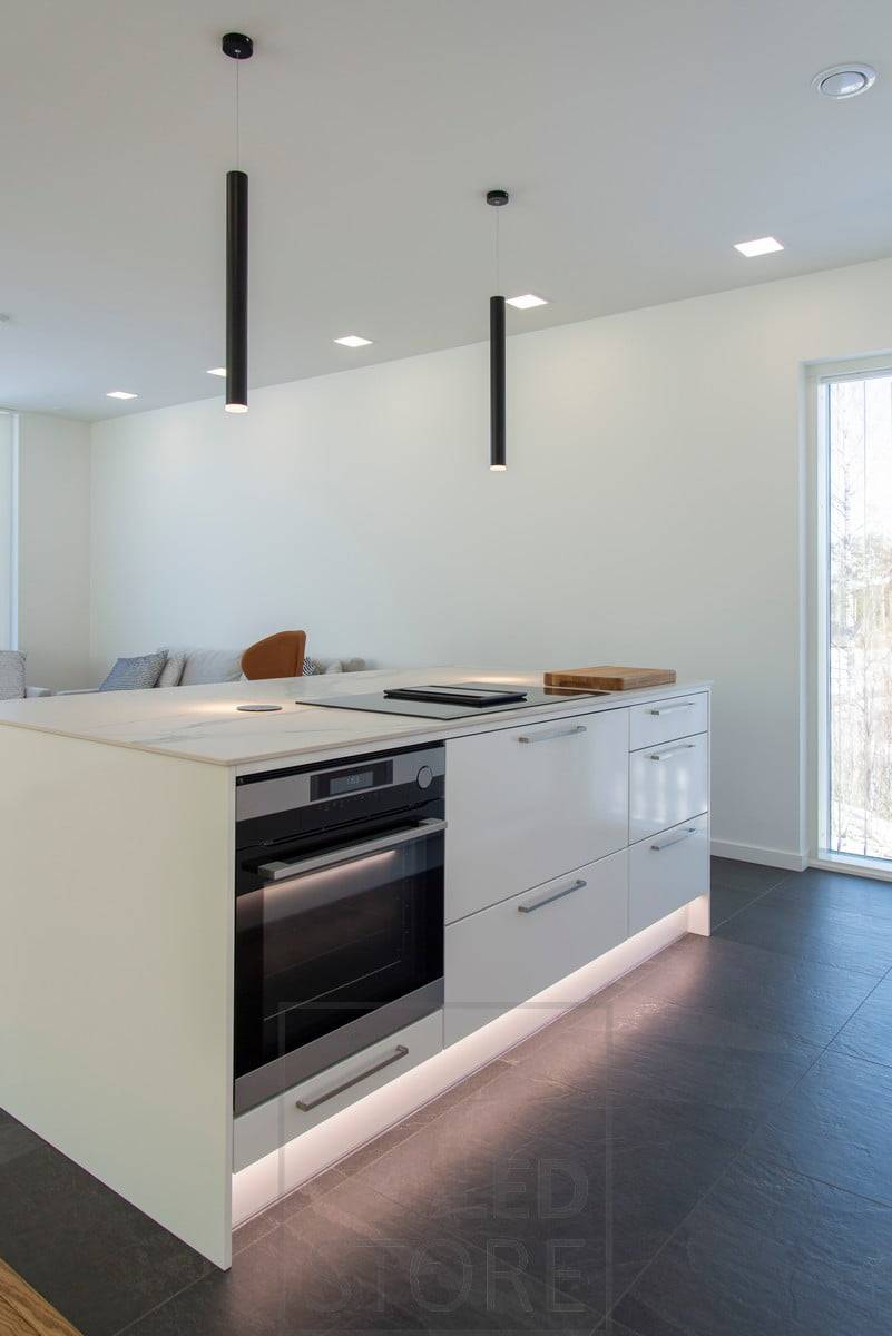 Paneele an der Decke, Kamin-Pendelleuchten am oberen Ende der Ebene und ein LED-Streifen als Stimmungslicht und Nachtlicht am Sockel. Ledstore.fi