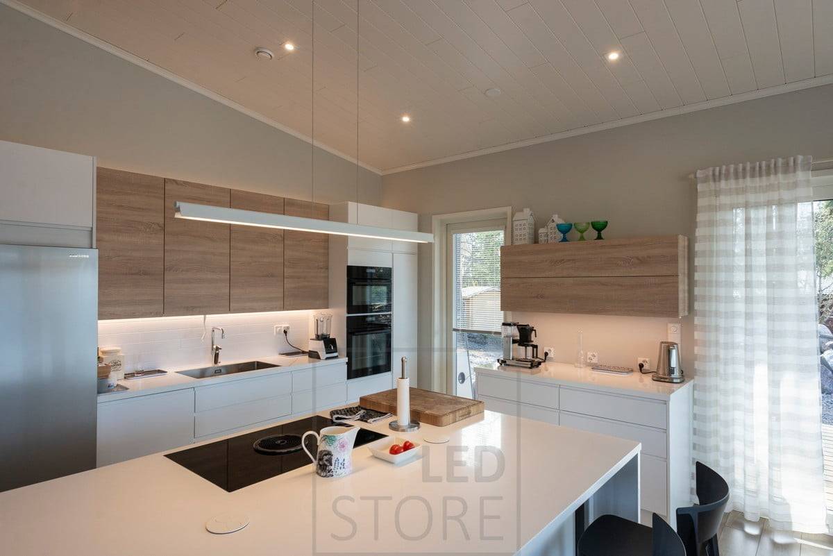 Arbeitslicht in der Küche mit LED-Streifen und zusätzlichen Spots an der Decke und einer Pendelleuchte über der Kochinsel. Ledstore.fi
