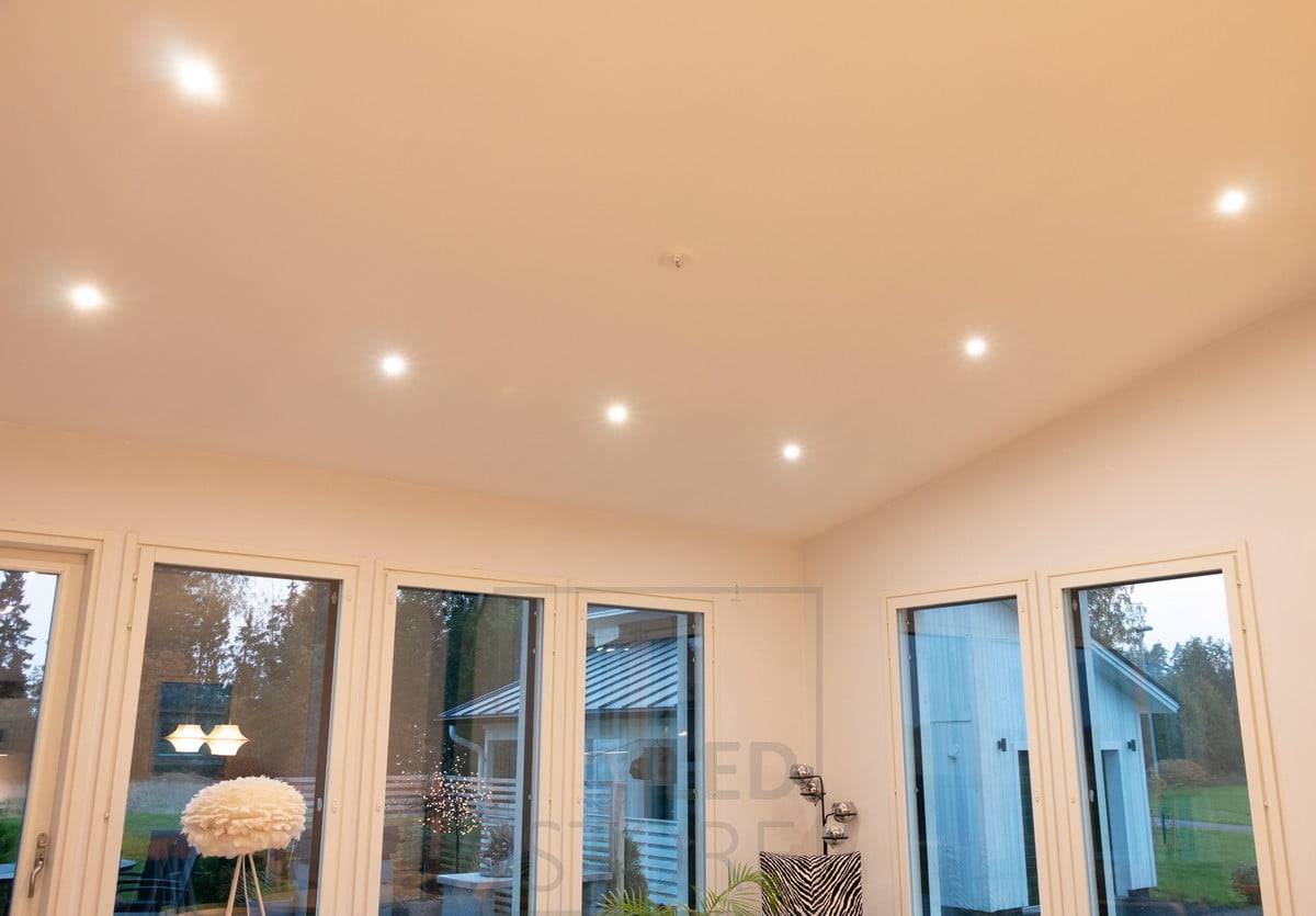 In der schrägen Decke drehen sich Richtstrahler im Wohnzimmer. Ledstore.fi