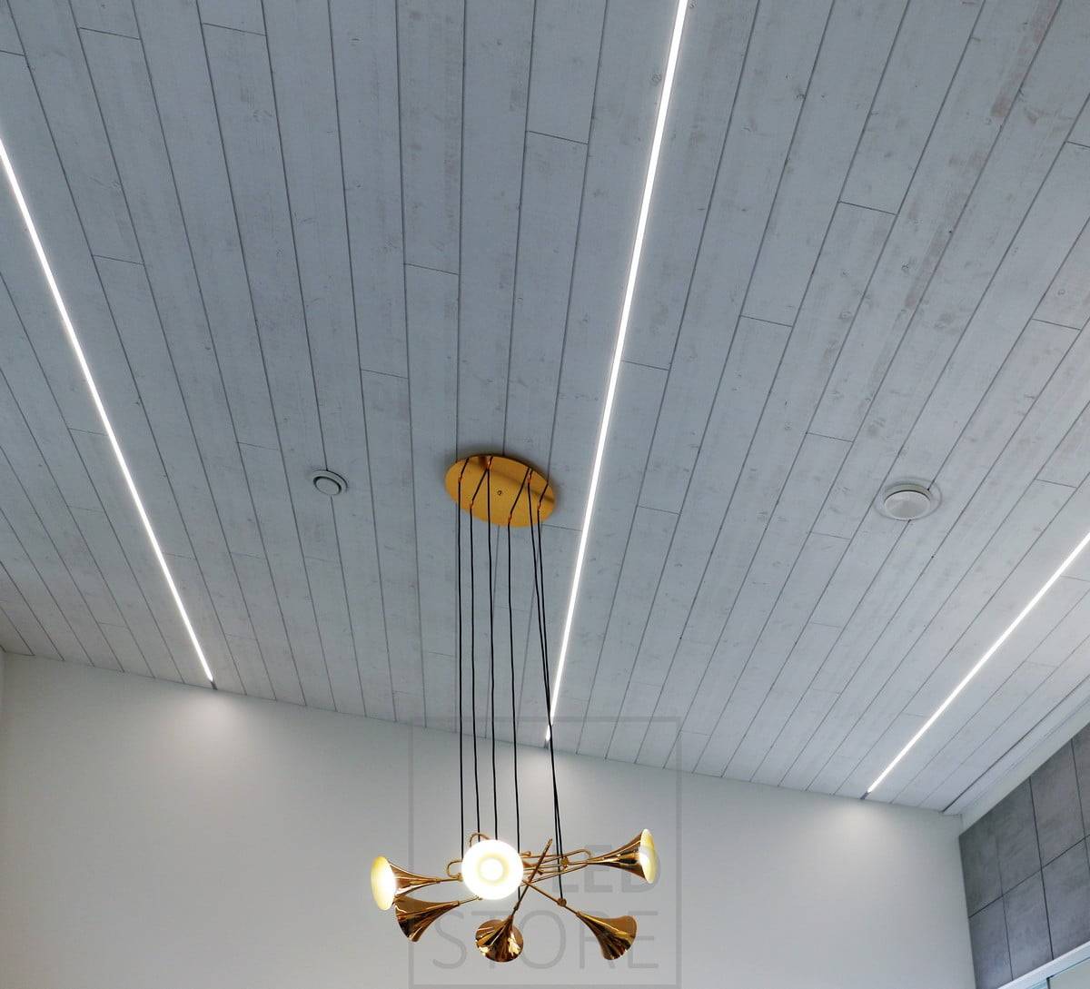 An der Decke sind über die gesamte Länge des Raumes LED-Streifen angebracht, die für eine angenehme Beleuchtung und ein modernes Aussehen sorgen. Ledstore.fi
