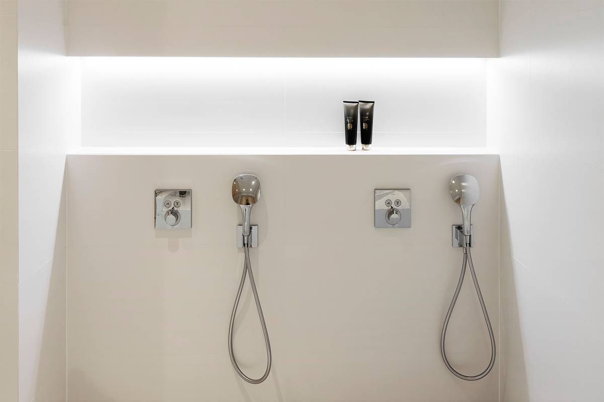 Shampoo-Regal im Badezimmer, in der oberen Ecke des Regals beleuchtet von einem LED-Streifen. Ledstore.fi