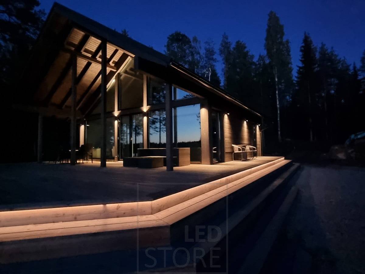 Vielseitige und stimmungsvolle Außenbeleuchtung mit LED-Streifen an der Treppe und Wandleuchten. Wandleuchten, die an einem hohen Punkt in zwei Richtungen und an einem niedrigen Punkt in eine Richtung leuchten. Ledstore.fi