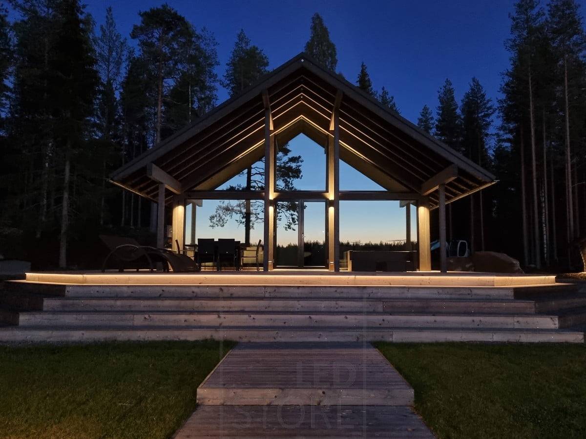 Vielseitige Außenbeleuchtung mit LED-Streifen an der Treppe und Wandleuchten. Wandleuchten, die an einem hohen Punkt in zwei Richtungen leuchten. Ledstore.fi
