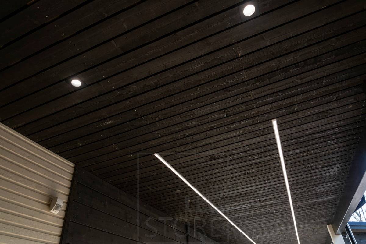 Scheinwerfer und LED-Streifen beleuchten ein Vordach im Freien. Ledstore.fi