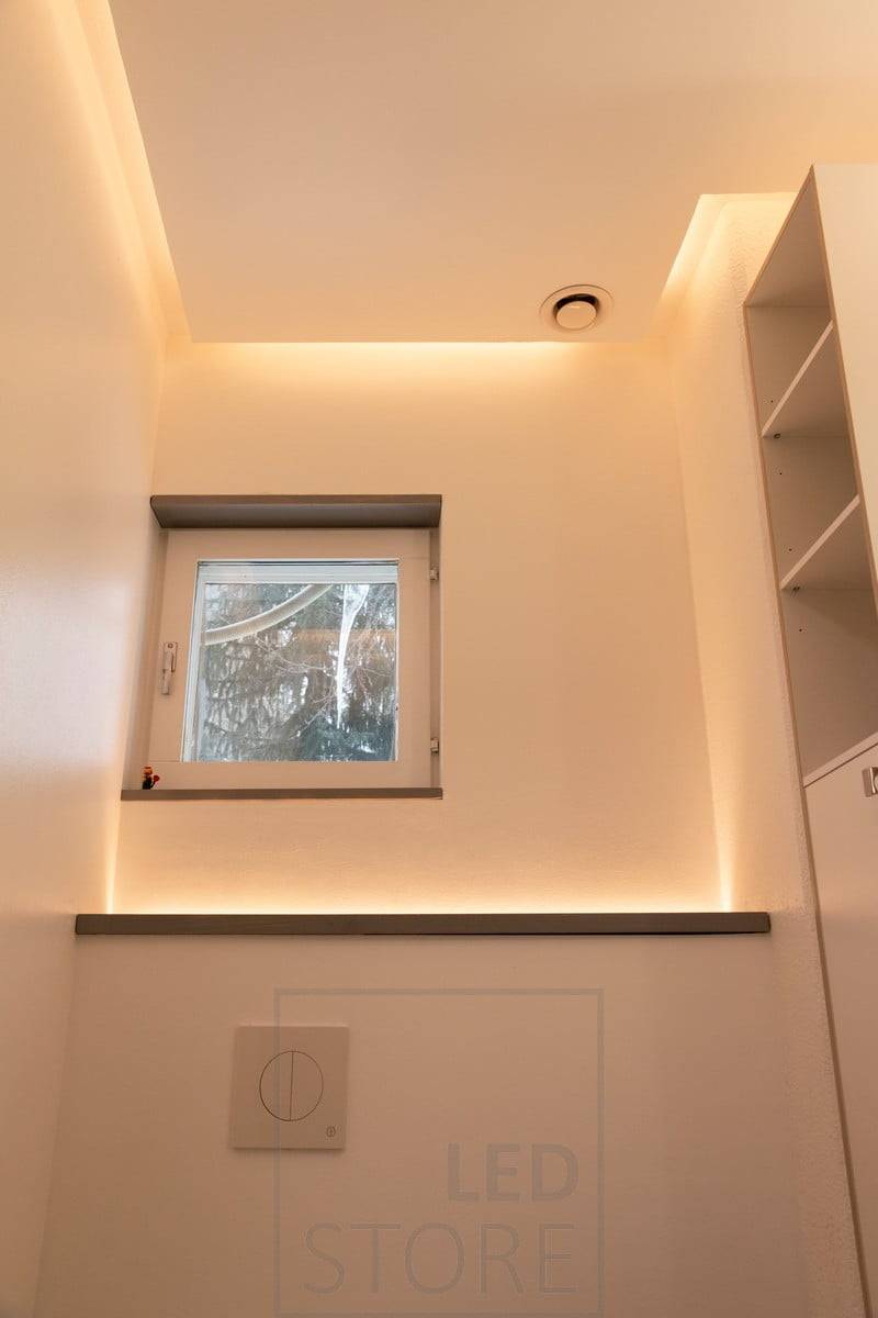 Eine an der Wand montierte Toilettenkabine mit einer nach oben gerichteten LED-Leiste. Es erzeugt ein stimmungsvolles Licht im Raum und wird durch einen Bewegungssensor eingeschaltet, so dass es auch als Nachtlicht funktioniert. An der Decke in der Dropdown-LED-Leiste, die auf die Wand gerichtet ist. Ledstore.fi
