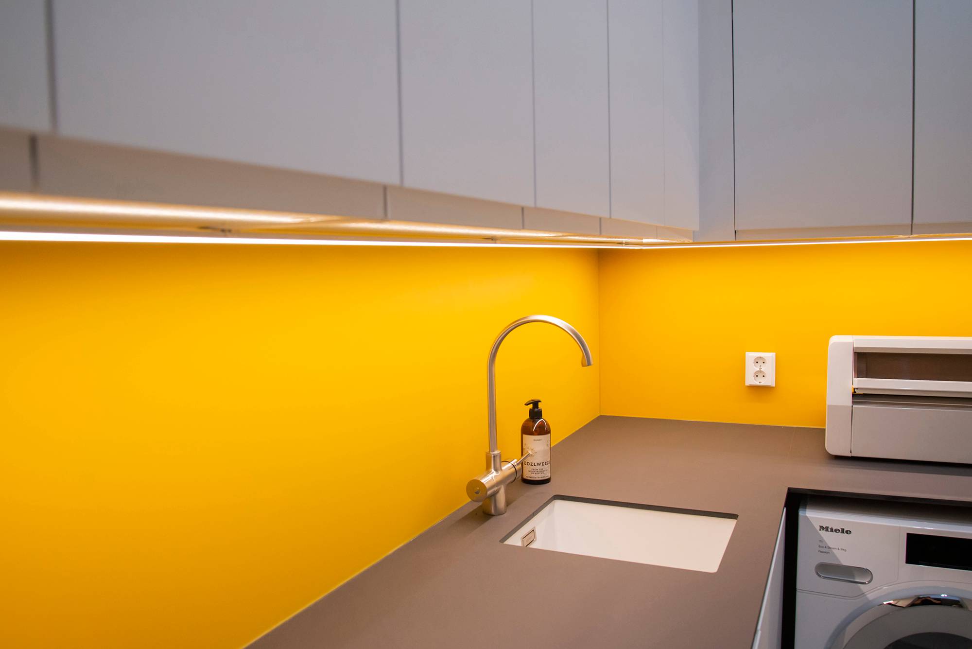 Mit LED-Streifen, die auf einem Oberflächenprofil montiert sind, wird Licht in die Ebenen des Hauswirtschaftsraums gebracht. Ledstore.fi
