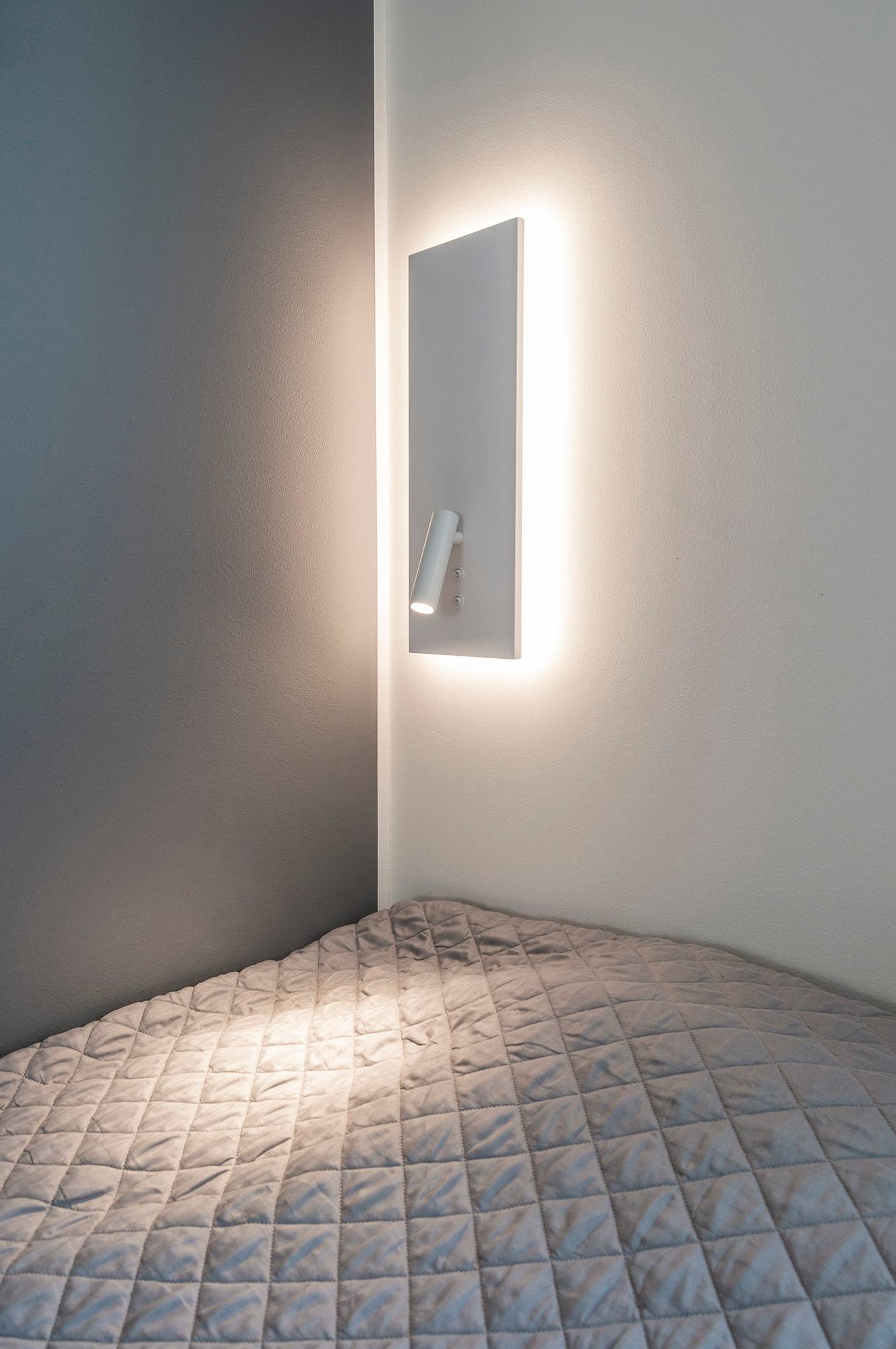 Wandleuchte NIGHT in Weiß. Mit indirektem und weichem Stimmungslicht im Hintergrund und einem gerichteten Leselicht, das mit einem separaten Schalter eingeschaltet wird. Ledstore.fi